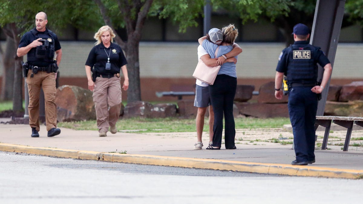 Two people hug outside at Memorial High School where people were evacuated from the scene of a shooting at the Natalie Medical Building Wednesday, June 1, 2022. in Tulsa, Okla. Multiple people were shot at a Tulsa medical building on a hospital campus Wednesday. (Ian Maule/Tulsa World via AP)