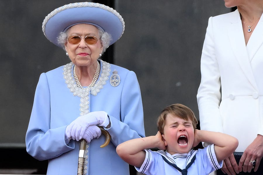 British Prince Louis of Cambridge holds his ears  next to Queen Elizabeth II as jets fly above Buckingham Palace's balcony as part of the queen's platinum jubilee celebrations in London.