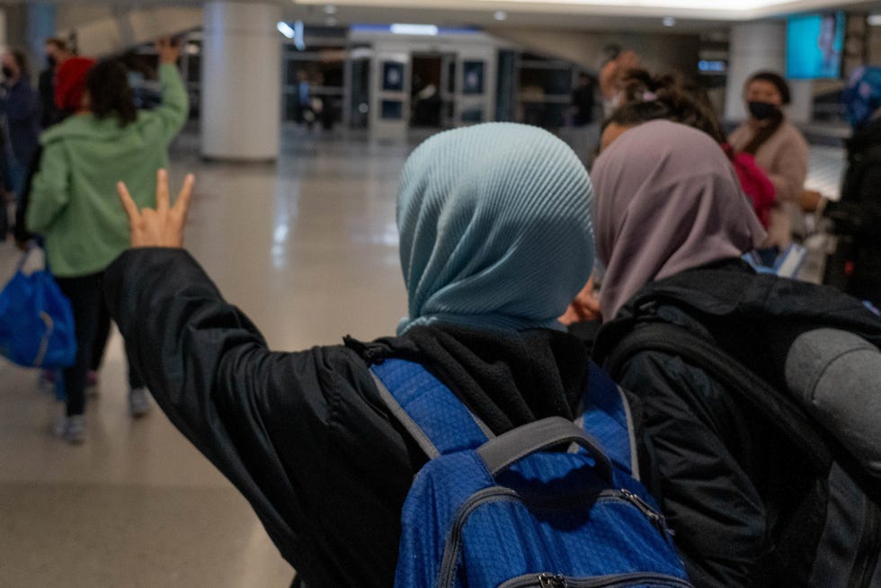 A female Afghan refugee holds up a pitchfork after arriving at Sky Harbor Airport in Phoenix on Dec. 15, 2021.