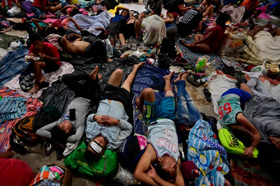 Migrants rest as they take part in a caravan, heading to the US-Mexico border, in Huixtla, Chiapas state, Mexico, on June 7, 2022.