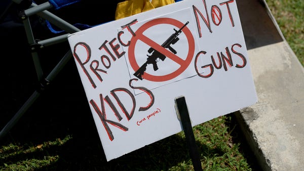 A sign rests on a chair during a vigil for victims