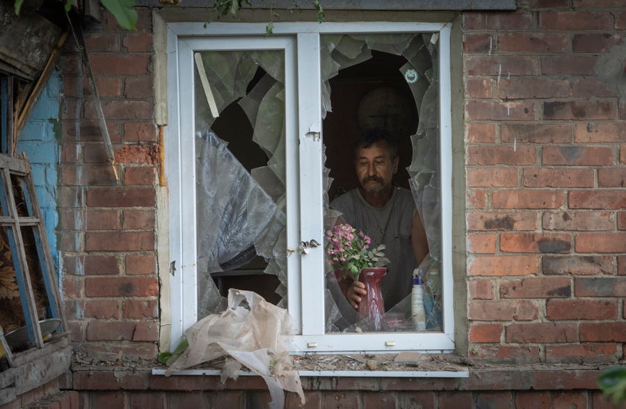 June 26, 2022:  A local resident places a vase with flowers on a broken window in his house damaged by the Russian shelling in Bakhmut, Donetsk region, Ukrain.