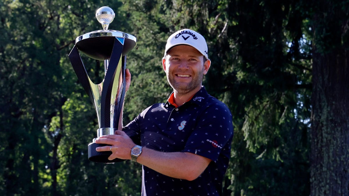 Branden Grace lifts his trophy after winning the LIV Golf tournament at Pumpkin Ridge Golf Club.