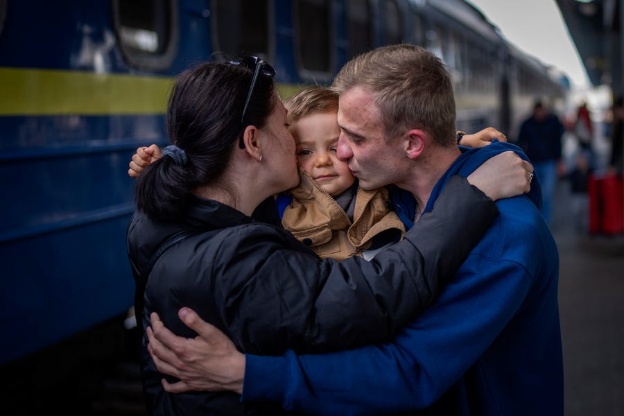 Oleksandr, 26, kisses his son Egor, 2, and his wife Alyona, 26, as they meet at the train station after more than two months separated by the war in Kyiv, Ukraine, on Saturday, April 23, 2022.