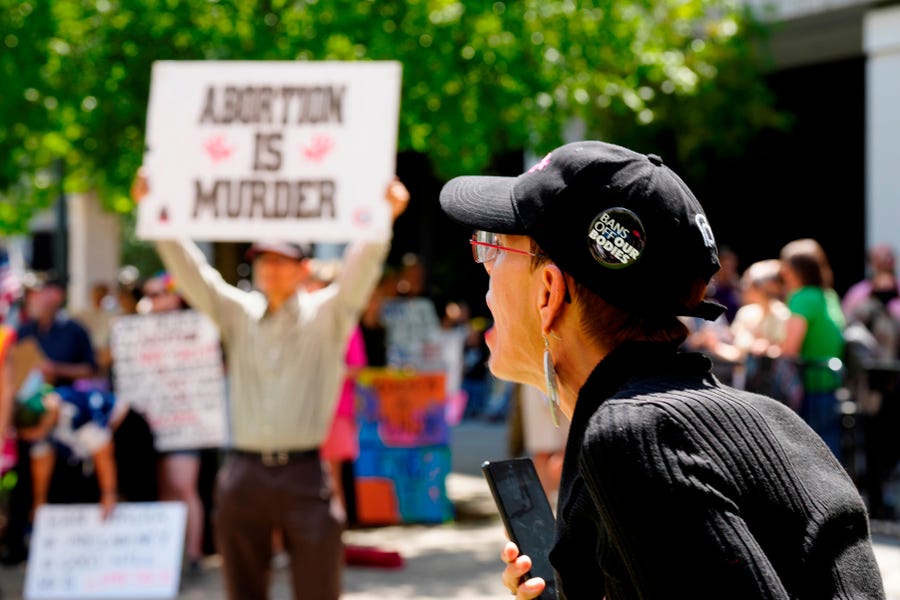 A woman supporting abortion rights shouts at anti-abortion protesters outside the South Carolina Statehouse on Thursday, July 7, 2022, in Columbia, South Carolina.