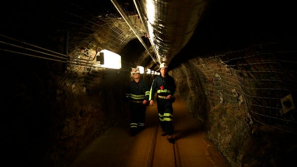 Two researchers walk through an old mining tunnel 