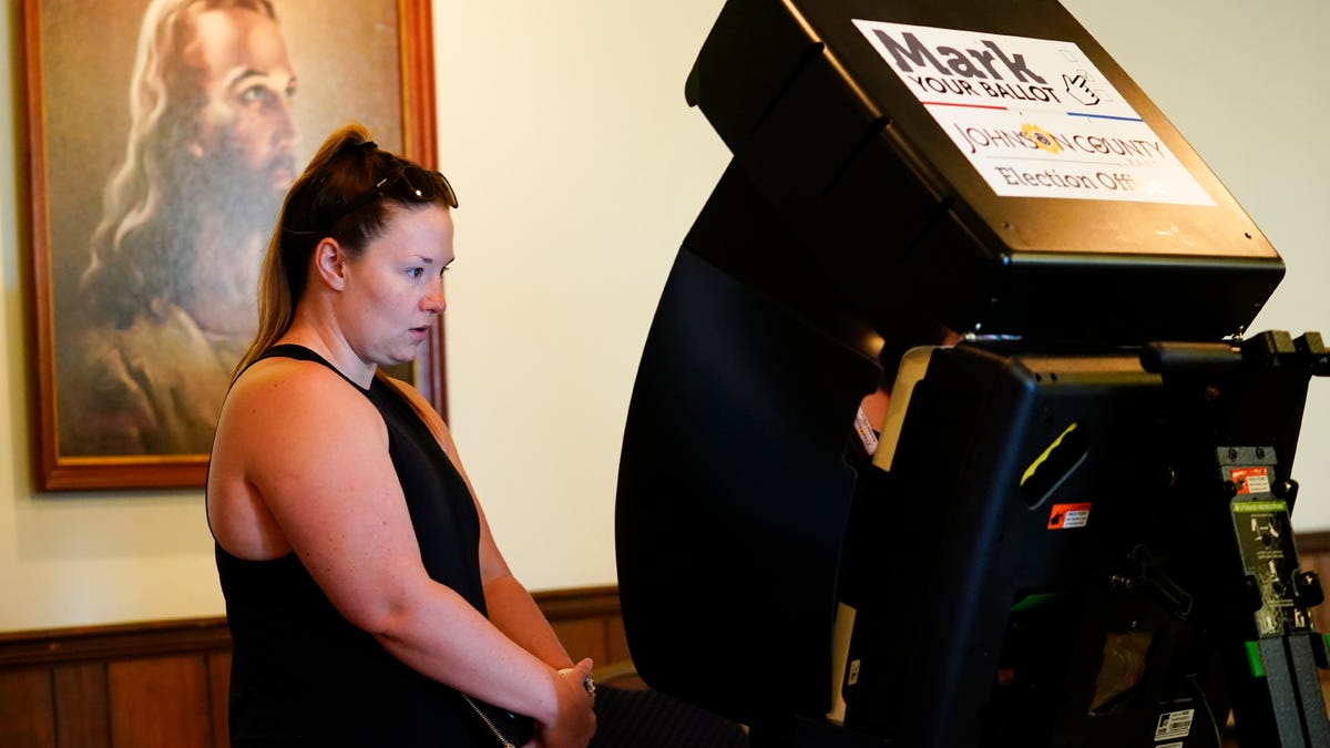 MERRIAM, KANSAS - AUGUST 02: A poll worker helps a voter cast their ballot in the Kansas Primary Election at Merriam Christian Church on August 02, 2022 in Merriam, Kansas. Voters in Kansas will decide on whether or not to remove protection for abortion from the state's constitution.