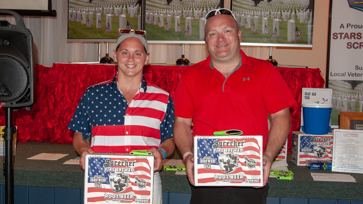 Sami Williams, left, and Ian Stawicki shared the prize of Sprecher Root Beer for the best hole of the Stars and Stripes Scramble thanks to their aces at The Golf Club at Camelot.