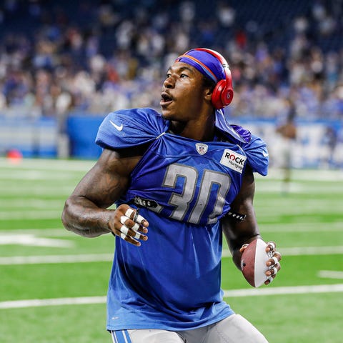 Lions running back Jamaal Williams tosses up a sig