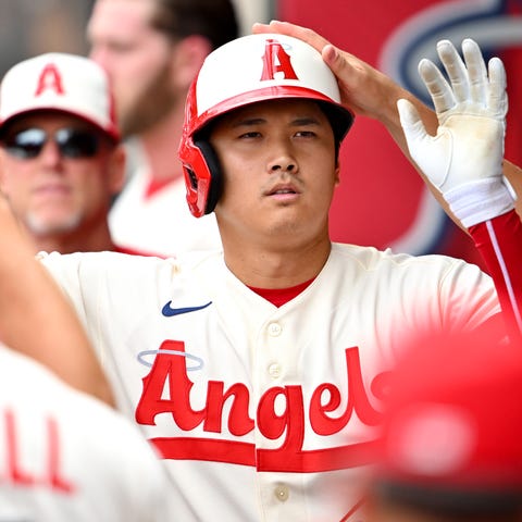 Shohei Ohtani is greeted in the dugout after hitti