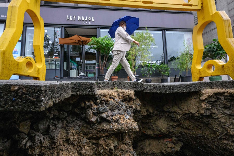 A man walks past a damaged pavement in Seoul Tuesday.