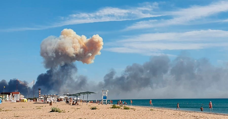 Rising smoke can be seen from the beach at Saky after explosions were heard from the direction of a Russian military airbase near Novofedorivka, Crimea, Tuesday Aug. 9, 2022.