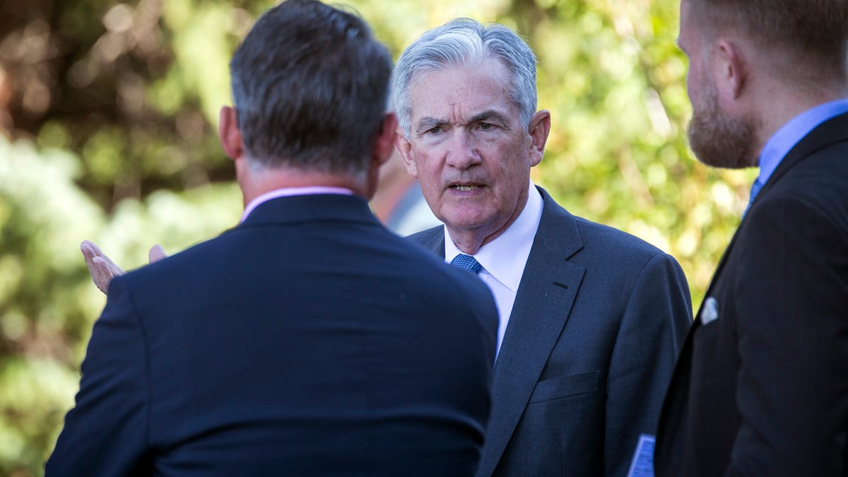 Federal Reserve Chair Jerome Powell, center, takes a coffee break with attendees of the central bank's annual symposium at Jackson Lake Lodge in Grand Teton National Park Friday, Aug. 26, 2022. in Moran, Wyo.