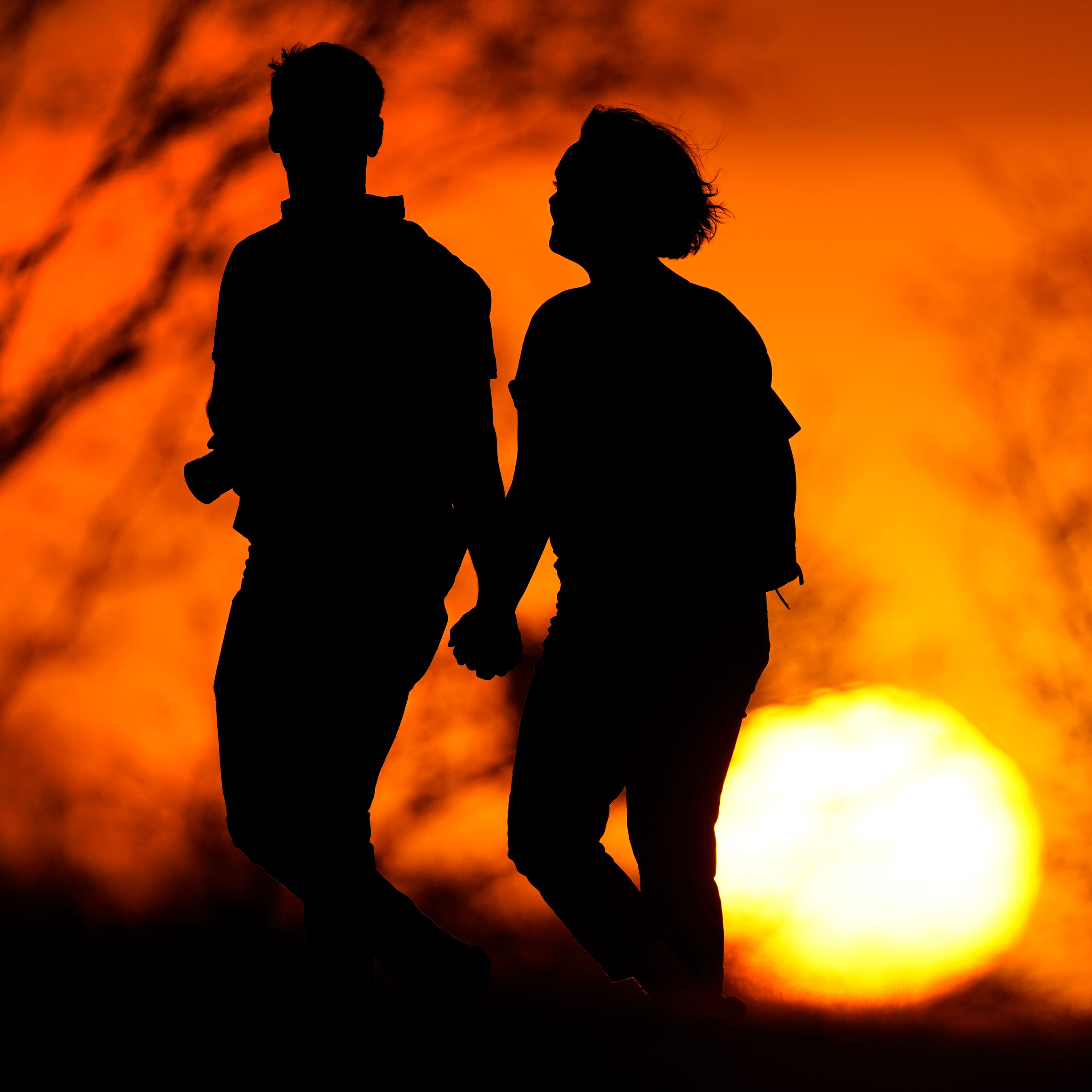 A couple walks through a park at sunset in Kansas City, Missouri. U.S. life expectancy dropped for two consecutive years in 2020 and 2021, marking the first such trend since the early 1920s, according to a new government report.