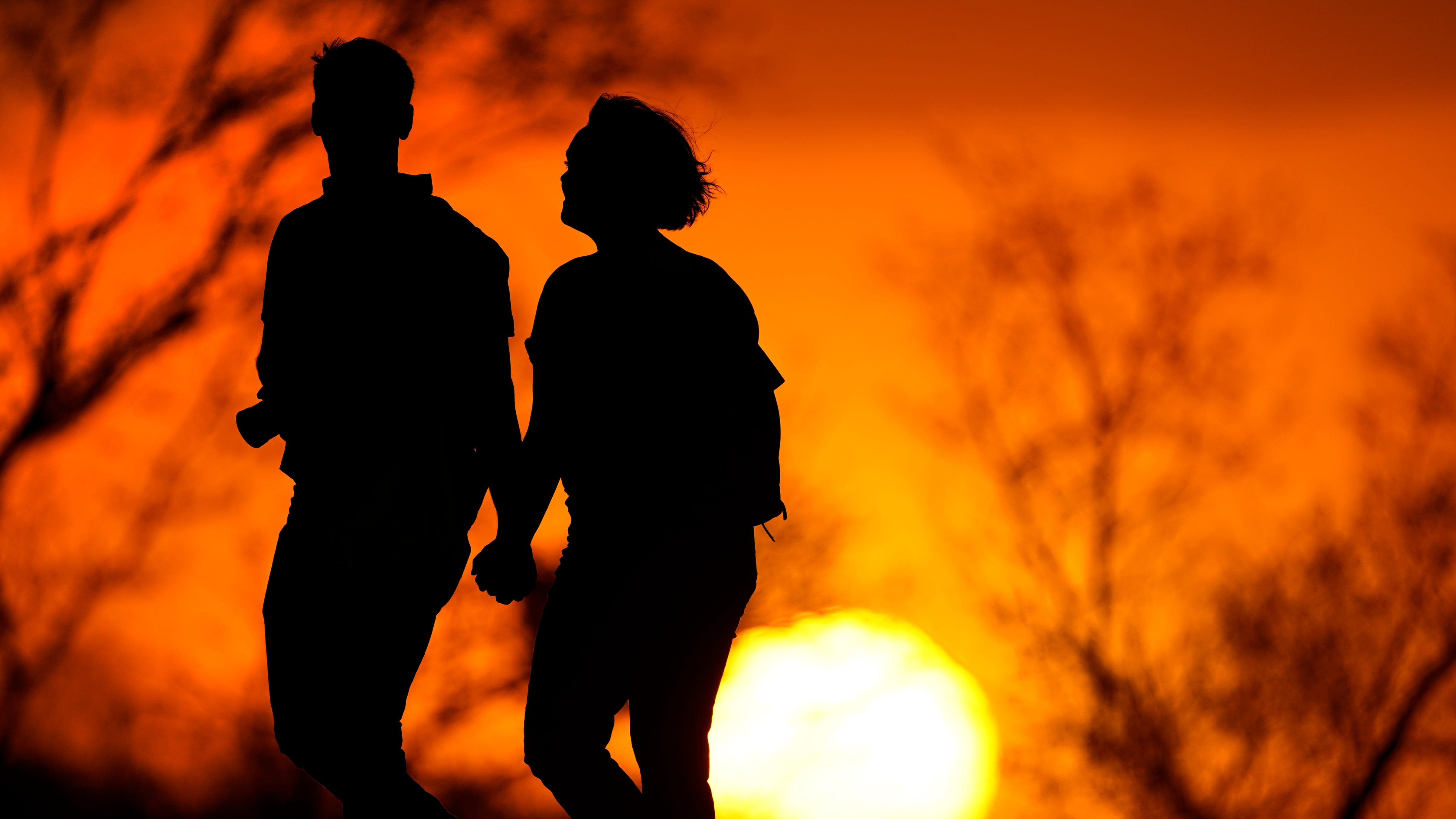 A couple walks through a park at sunset in Kansas City, Missouri. U.S. life expectancy dropped for two consecutive years in 2020 and 2021, marking the first such trend since the early 1920s, according to a new government report.