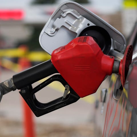 A motorist fills up the tank on a sedan, on July 2