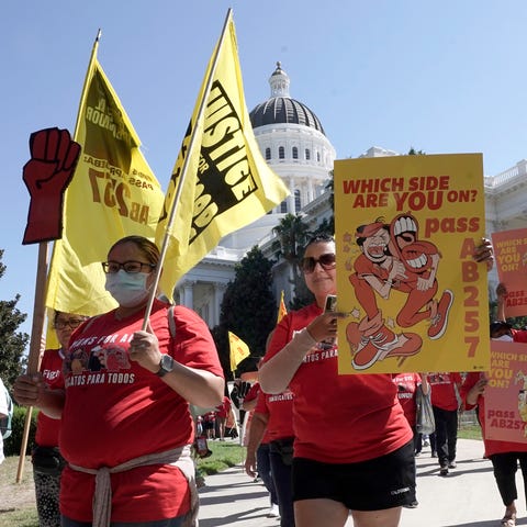 Fast food workers and their supporters march past 