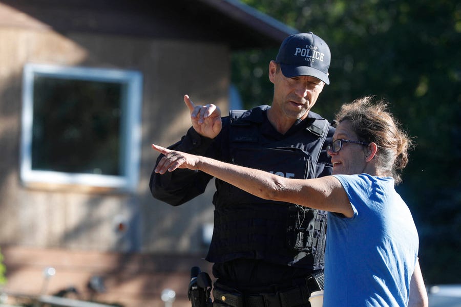 Ruby Works, a friend of Wes Petterson, speaks to a Royal Canadian Mounted Police officer outside Petterson's home in Weldon, Saskatchewan, Canada, on September 6, 2022. Petterson has been identified as one of the stabbing victims.