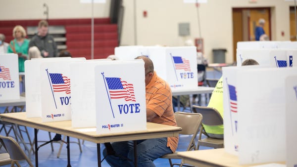 A voter fills out their ballot at Bedford High Sch