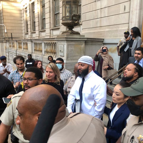 Adnan Syed, center, leaves the Elijah E. Cummings 