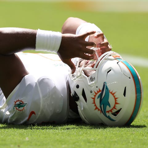 Dolphins QB Tua Tagovailoa lays on the turf after 