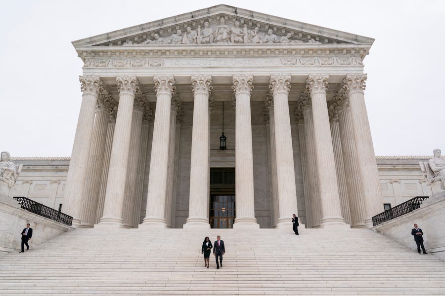 Justice Ketanji Brown Jackson, center left, is escorted by Chief Justice of the United States John Roberts following her formal investiture ceremony at the Supreme Court in Washington, Friday, Sept. 30, 2022. (AP Photo/J. Scott Applewhite) ORG XMIT: DCSA115