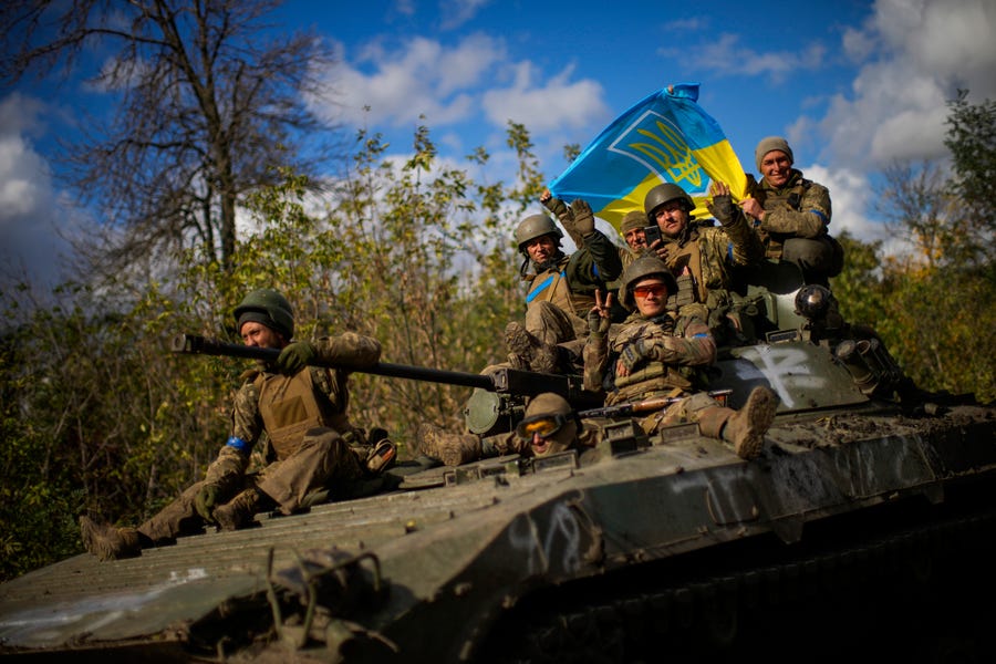 Ukrainian soldiers sit on an armoured vehicle as they drive on a road between Izium and Lyman in Ukraine, Tuesday Oct. 4, 2022.