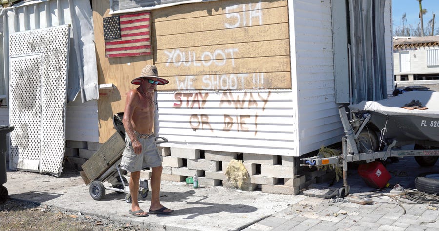 Curtis Eggleston carries some of his belongings out of his hurricane-damaged home on Pine Island on Monday, Oct. 4, 2022.