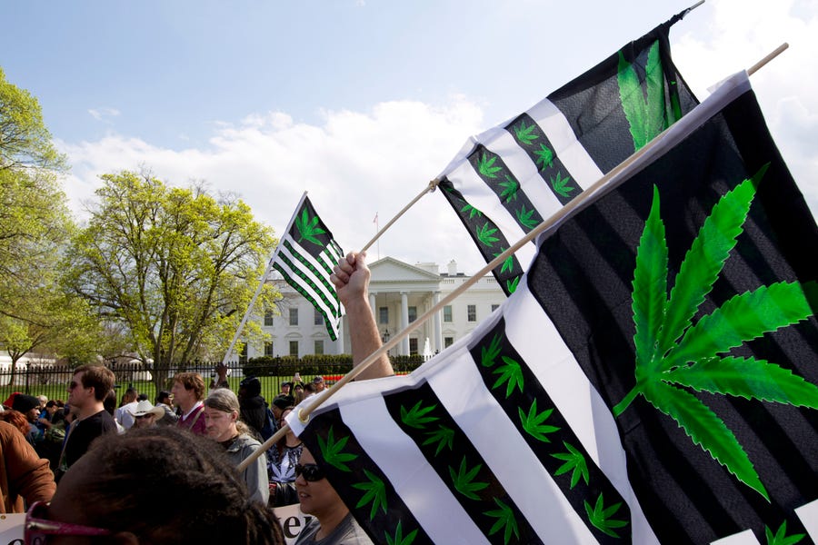 A demonstrator waves a flag with marijuana leaves depicted on it during a protest calling for the legalization of marijuana, outside of the White House on April 2, 2016, in Washington.