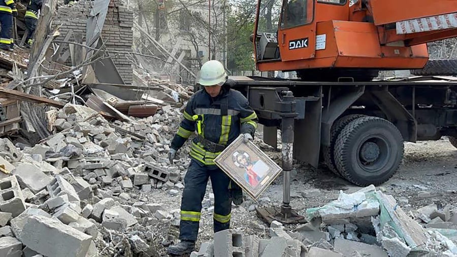 In this photo provided by the Ukrainian Emergency Service, a rescue worker at the scene of a building damaged by shelling in Zaporizhzhia, Ukraine, Thursday, Oct. 6, 2022.