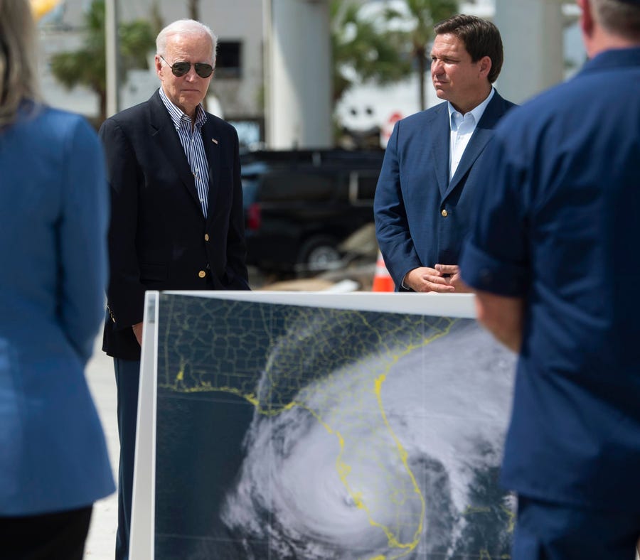 President Joe Biden, left, and Florida Gov. Ron DeSantis, right, meet with residents and emergency workers during a visit to Fisherman's Wharf at Fort Myers Beach, Fla., Wednesday, Oct. 5, 2022, to see the damage caused by Hurricane Ian.