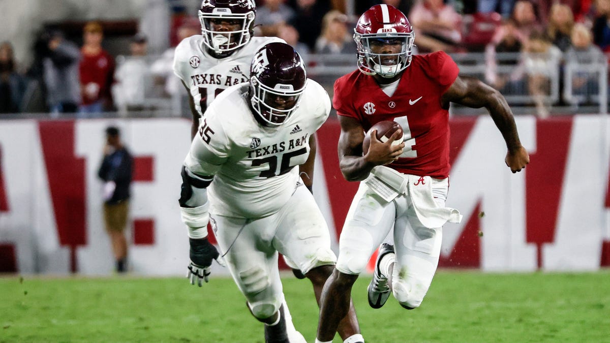 Alabama quarterback Jalen Milroe (4) scrambles away from Texas A&M defensive lineman McKinnley Jackson (35) during the first half at Bryant-Denny Stadium.