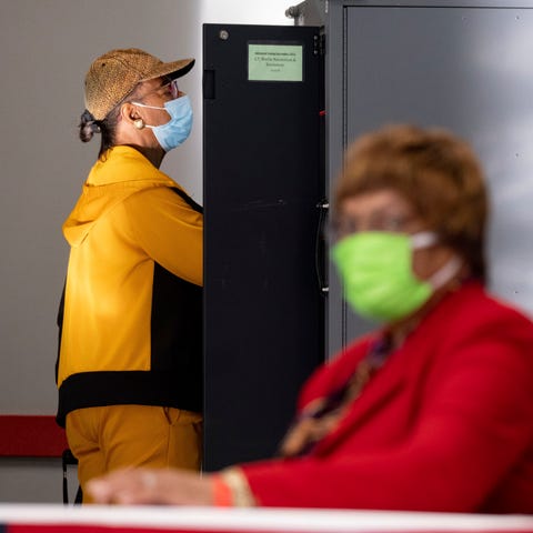 A voter marks her ballot during the first day of e