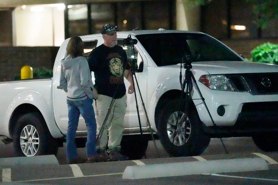 A group watches and records a ballot drop box in Mesa, Ariz.. Several voting rights groups are asking federal judges to stop ballot box observers from staking out Arizona voting locations.