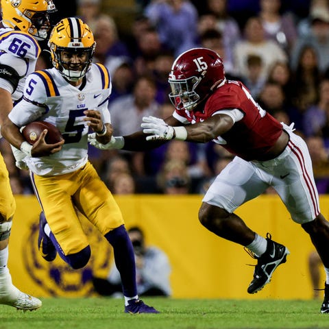 LSU quarterback Jayden Daniels (5) scrambles out t