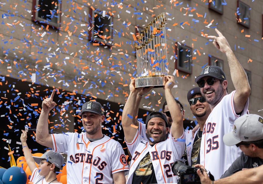 The Houston Astros' Alex Bregman (2), Jose Altuve (27) and Justin Verlander (35) celebrate with the 2022 Commissioner's Trophy during the championship parade in Houston.