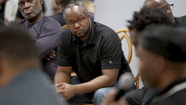 A Georgia man listens to a fellow attendee speak a