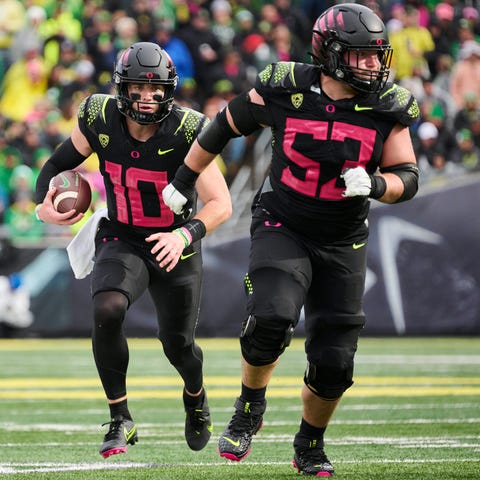 Oregon quarterback Bo Nix (10) carries the ball wi