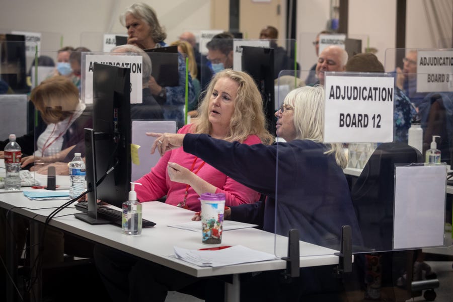 An adjucation board reviews ballots at the Maricopa County Tabulation and Election Center on November 08, 2022 in Phoenix, Arizona. Bill Gates, Chairman of the Maricopa Board of Supervisors, said that about 20 percent of polling stations in the county have had tabulation machine malfunctions, where some ballots cannot be read.