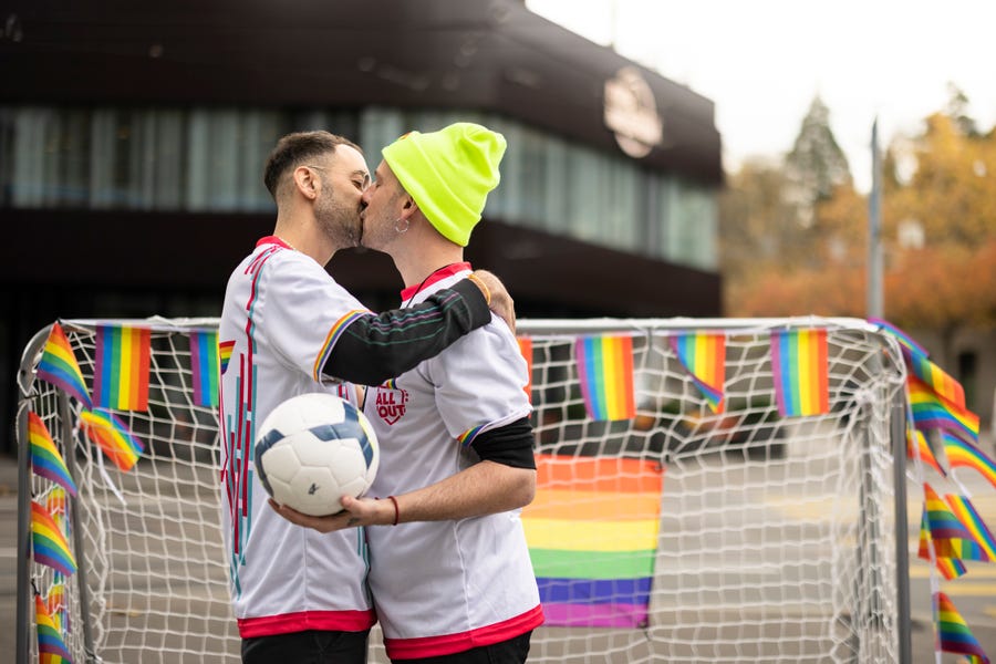 Protestors kiss while holding a football during a rally to raise awareness of the human rights situation of LGBTQ people in Qatar and FIFA's responsibility, in front of the FIFA Museum in Zurich, Switzerland, Tuesday, Nov. 8, 2022. An ambassador for the World Cup in Qatar has described homosexuality as a 