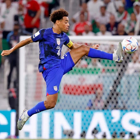 USMNT caption Tyler Adams kicks the ball against I