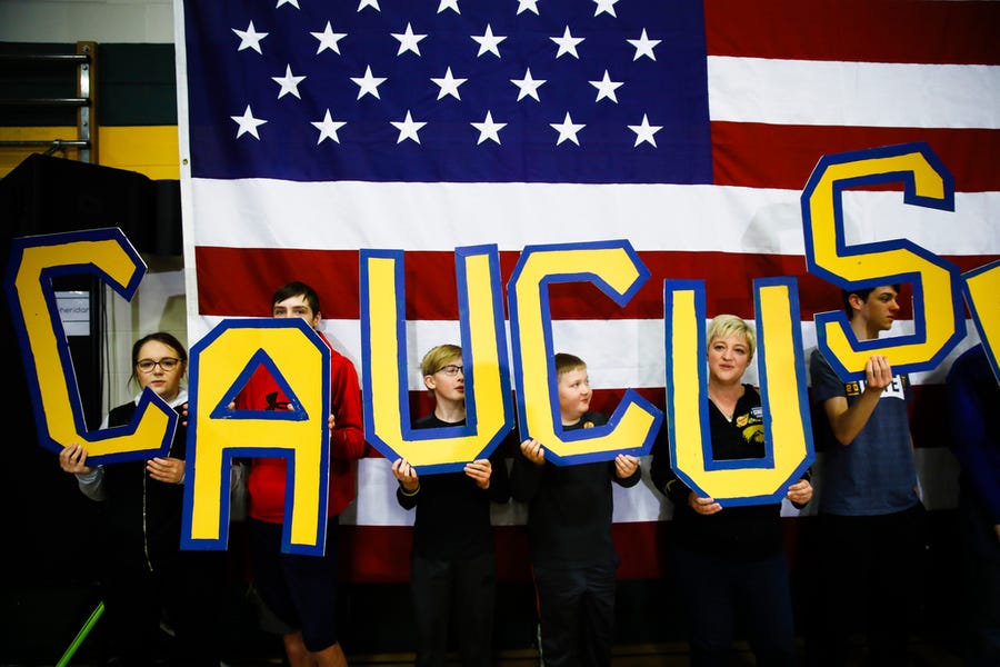 Attendees hold letters that read "CAUCUS" during a campaign event for Democratic presidential candidate former South Bend, Ind., Mayor Pete Buttigieg at Northwest Junior High, in Coralville, Iowa on Feb. 2, 2020.