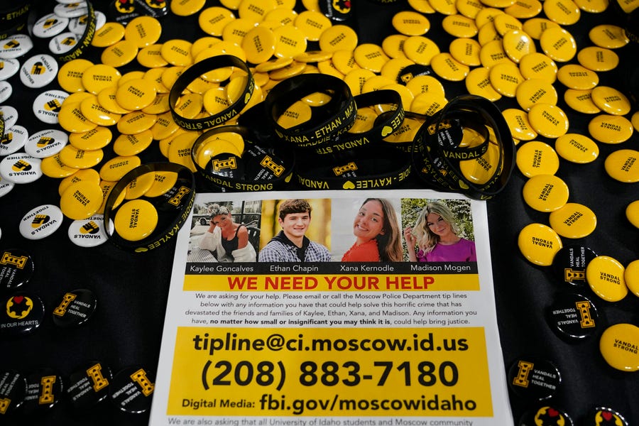 A flyer seeking information about the killings of four University of Idaho students who were found dead is displayed on a table along with buttons and bracelets, on Nov. 30, 2022, during a vigil in memory of the victims in Moscow, Idaho. It's been nearly three weeks since four University of Idaho students were found stabbed to death in a home near campus, but there are still more questions than answers surrounding the investigation.