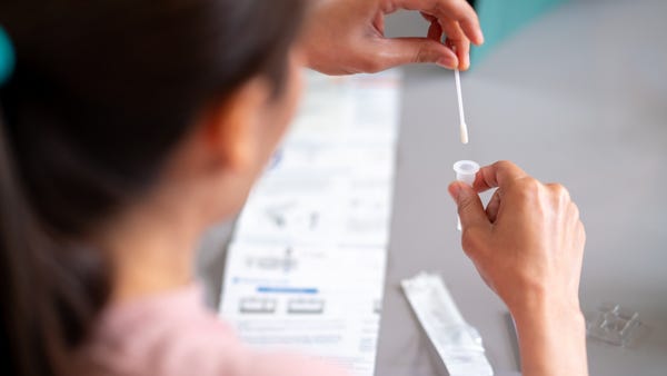 Woman using rapid antigen test kit for self test C