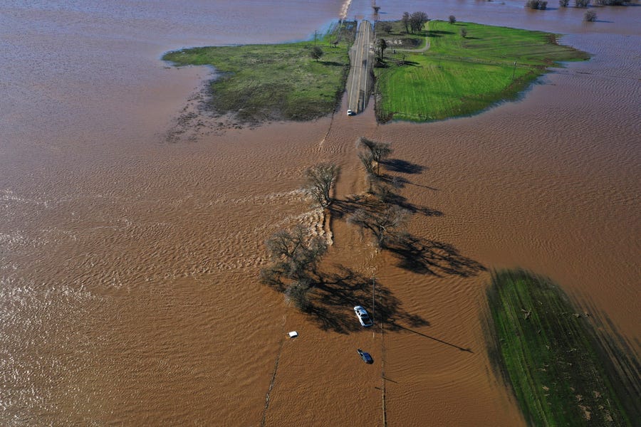 Three vehicles are submerged on Dillard Road west of Highway 99 in south Sacramento County in Wilton, Calif., Sunday, Jan. 1, 2023, after heavy rains on New Year's Eve produced levee breaks. Saturday's system was warmer and wetter, while storms this week will be colder, said Hannah Chandler-Cooley, a meteorologist at the National Weather Service in Sacramento. The Sacramento region could receive a total of 4 to 5 inches of rain over the week, Chandler-Cooley said.