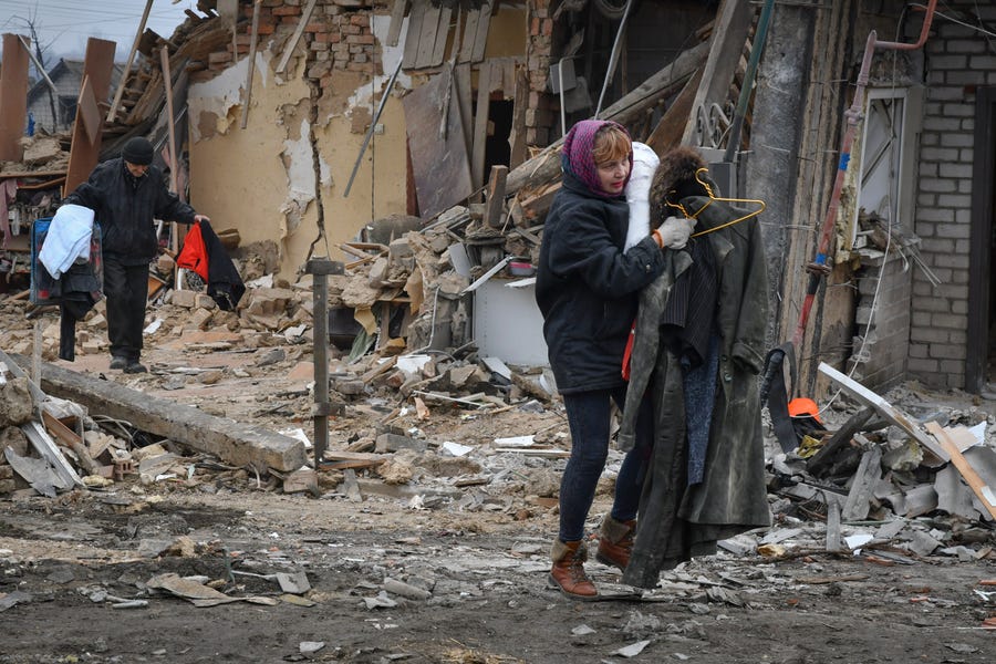 Local residents carry their belongings as they leave their home ruined in the Saturday Russian rocket attack in Zaporizhzhya, Ukraine, Sunday, Jan. 1, 2023. (AP Photo/Andriy Andriyenko) ORG XMIT: XEL102