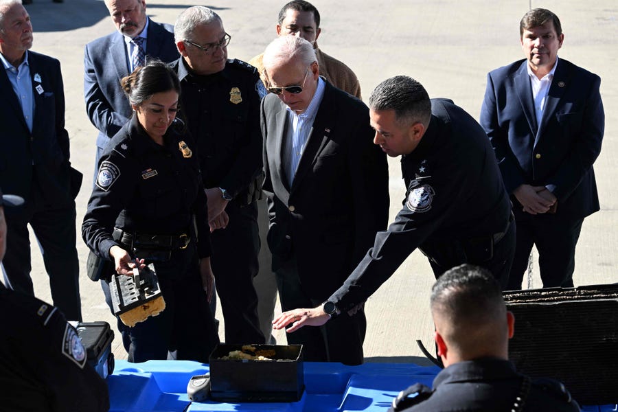 President Joe Biden listens to US Customs and Border Protection police as he looks at a fake battery used for smuggling drugs on the Bridge of the Americas border crossing between Mexico and the US in El Paso, Texas, on January 8, 2023.