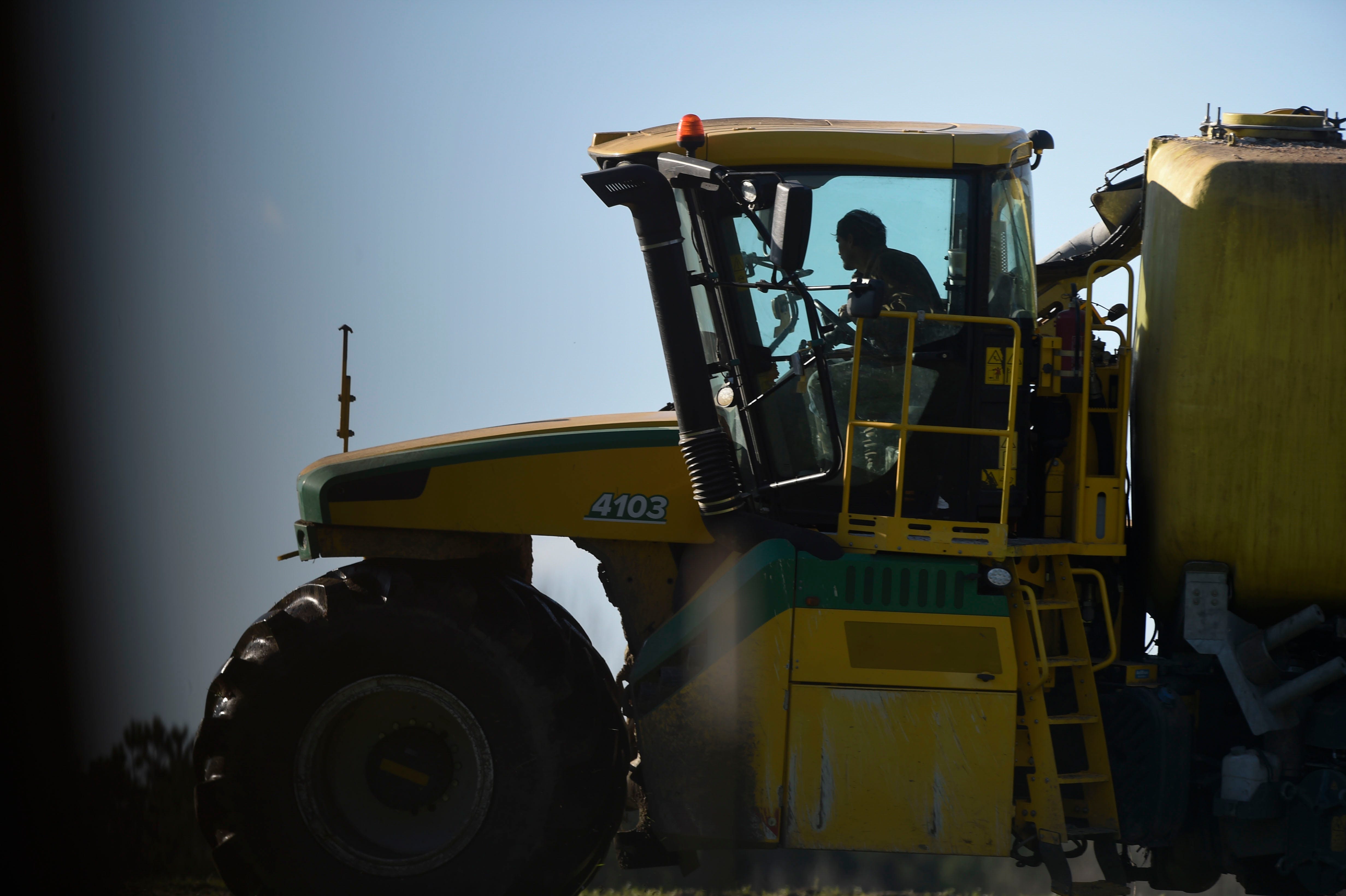 On Jan. 26, 2023, a tractor pulling a tank full of soil amendment sprays the soil on a farm near Warren County, Ga.