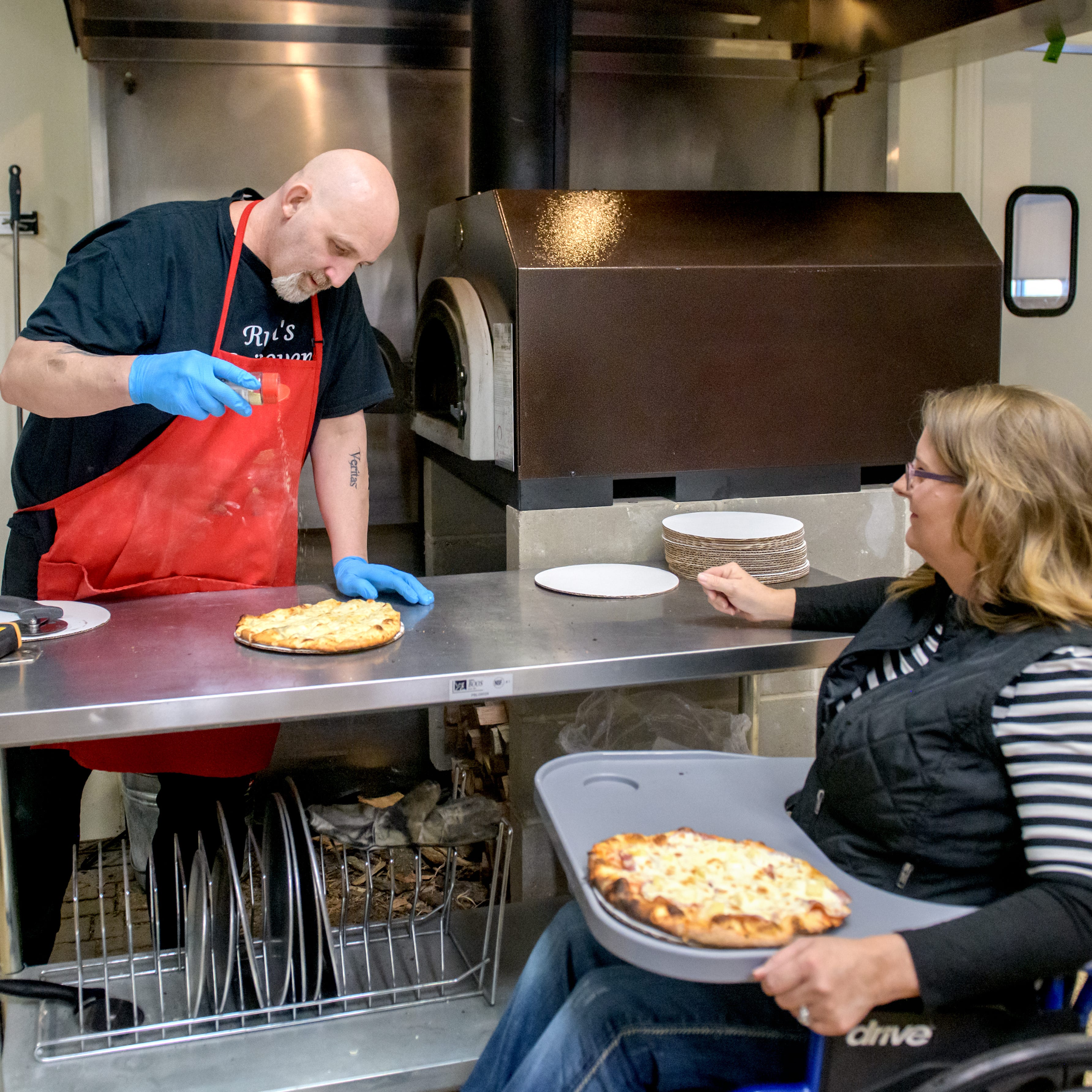 Dan and Michele Reubin prepare pizzas for lunchtime customers at their new business Rubi's Brickoven Pizza currently operating out of The Table in North Peoria.