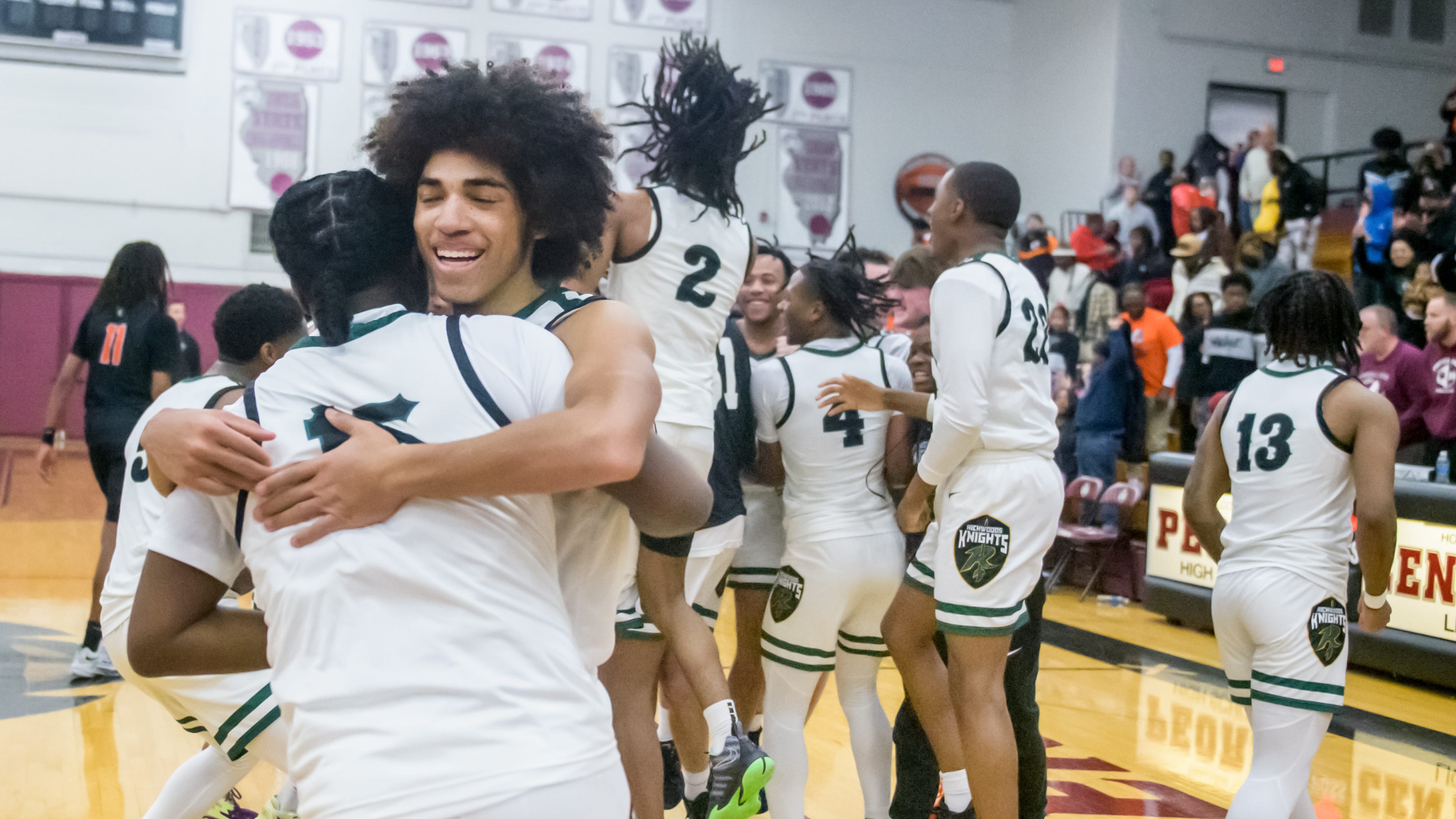 Richwoods senior Greg Burnside, facing, hugs teammate Jaylen McFadden after the Knight's 64-56 victory over Manual in the Class 3A Boys Basketball Peoria Regional title game Friday, Feb. 24, 2023 at Peoria High School.